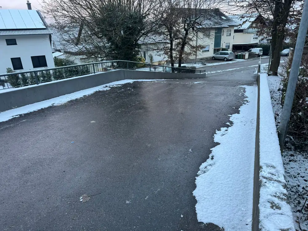 Geräumte Zufahrt im Winter, am Rand liegt noch Schnee