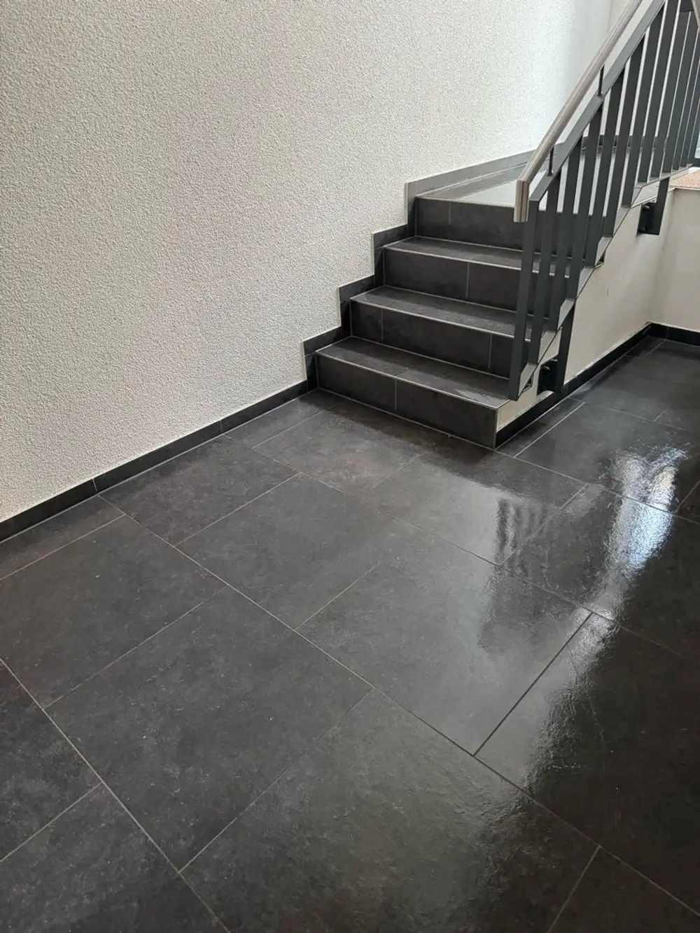 Gereinigter Flur mit dunklem Boden und Treppe