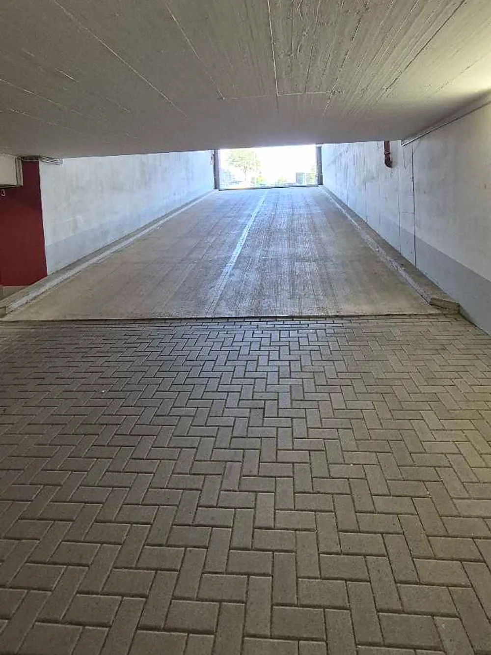 Saubere Ausfahrtsrampe in einer Tiefgarage mit Pflasterboden