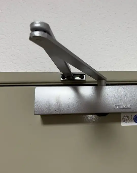 Türschließer an einer Tür im Treppenhaus