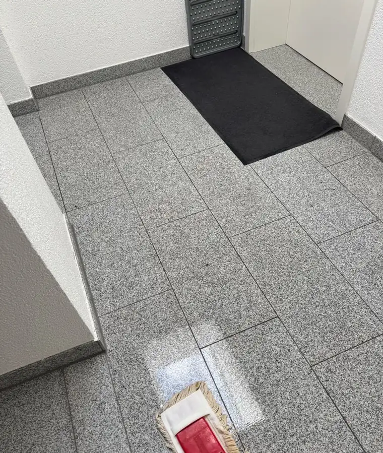 Wischmopp auf gewischtem Granitboden im Eingangsbereich